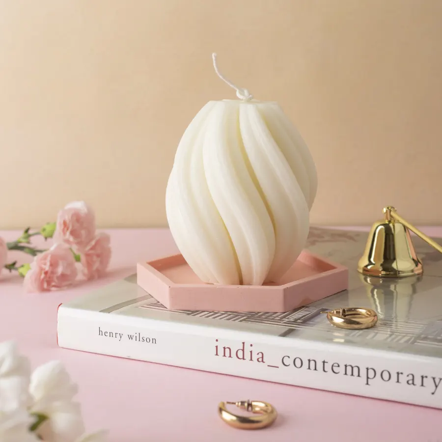 White Twirl Candle by Windowsill on a pink tray, with a book, gold snuffer, and pink flowers, showcasing aesthetic decor.