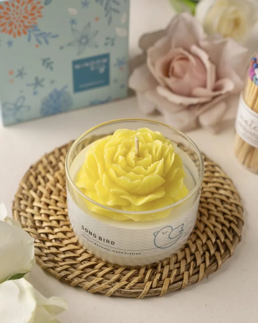 Yellow peony candle in a glass jar by Windowsill, with floral packaging and matches, showcasing biophilia-inspired decor.